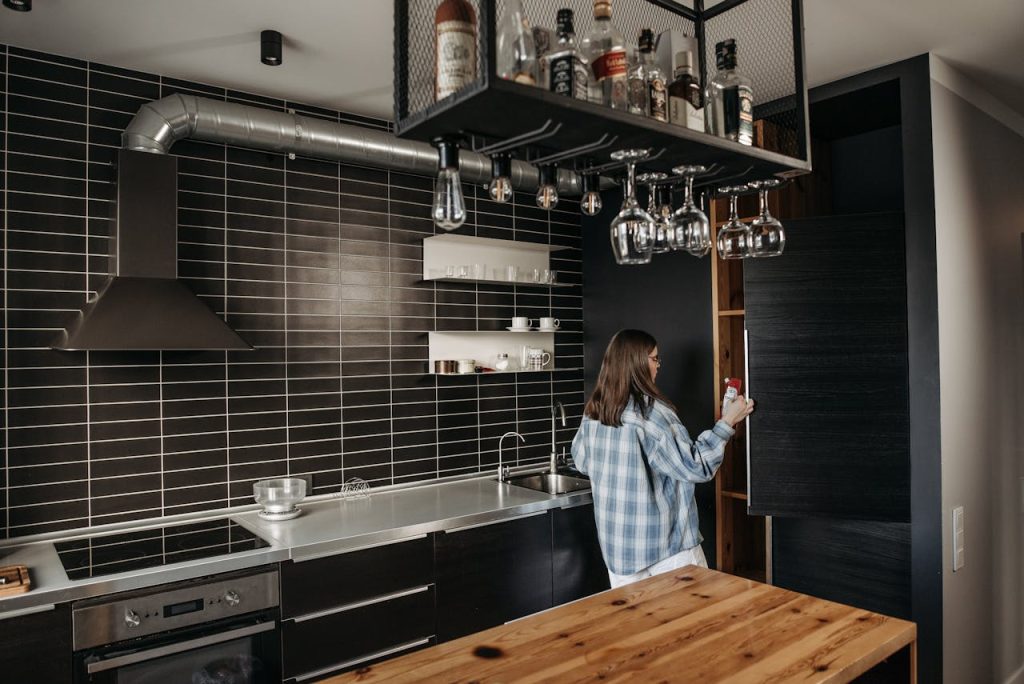 Luxurious modern kitchen with woman opening a cabinet. Ideal for contemporary design concepts.